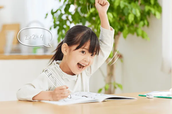 Criança feliz comemorando acerto em atividade de tabuada – métodos para ensinar multiplicação.