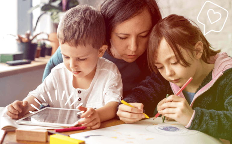 Mãe ajudando crianças a estudar com tablet e desenhos – aplicativos para aprender tabuada de forma interativa.